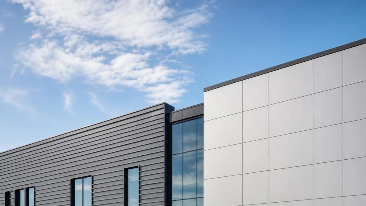 Commercial office facade combining solid aluminum profiles with broad metal panel surfaces